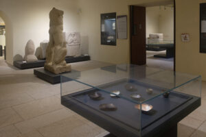 Vue de l'exposition Vases Communicants de Natacha Baluteau au Musée des Beaux-Arts de Limoges. Installation d'émaux sur cuivre contemporains en vitrine, dialoguant avec des sculptures antiques et les objets des collections archéologiques du Musée.