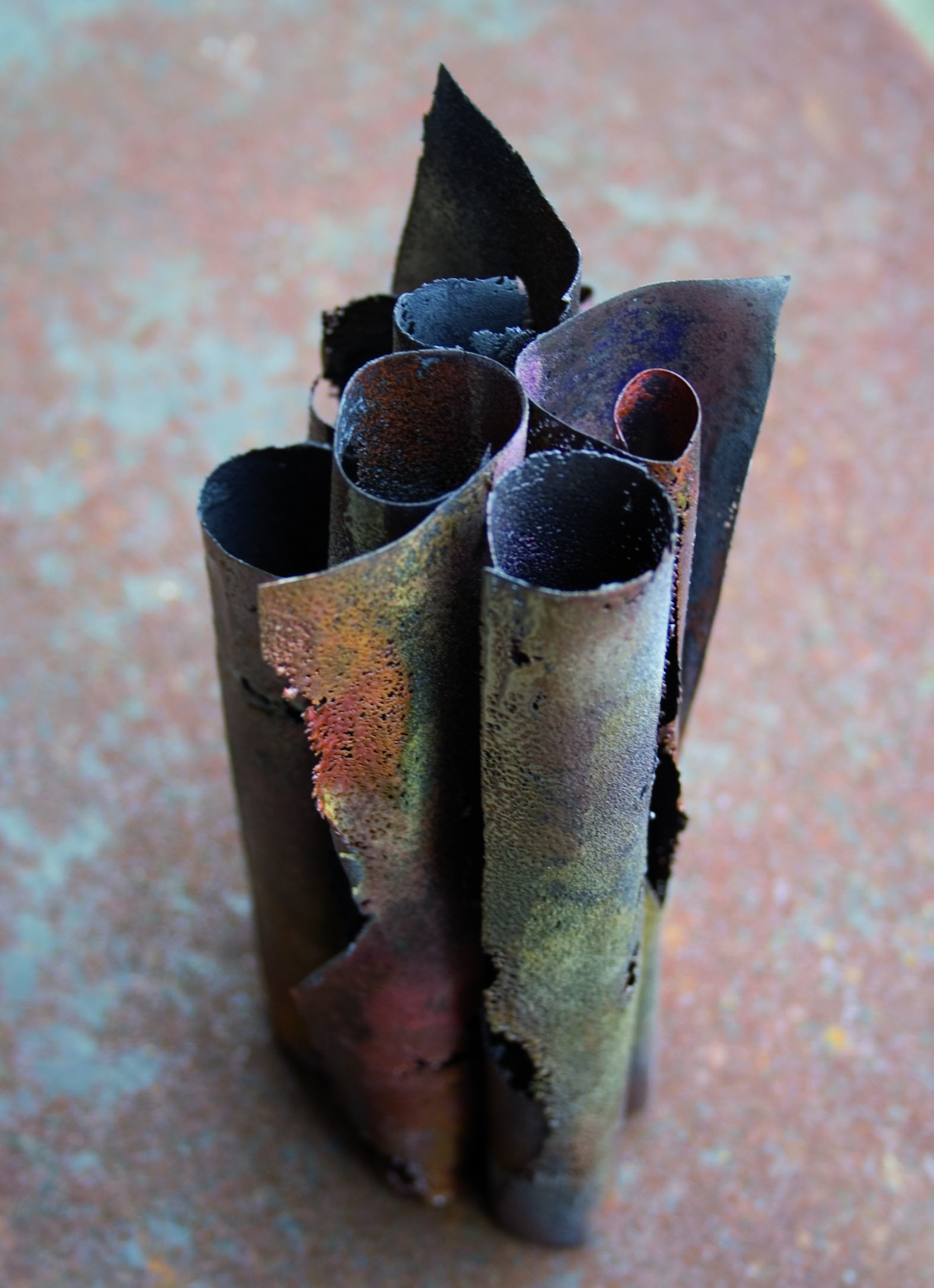 Sculpture contemporaine en volume de Natacha Baluteau, réalisée en émail sur cuivre. Le cuivre oxydé présente des nuances de brun foncé, avec des touches subtiles de rouge, de violet et de vert, révélant une matière brute.